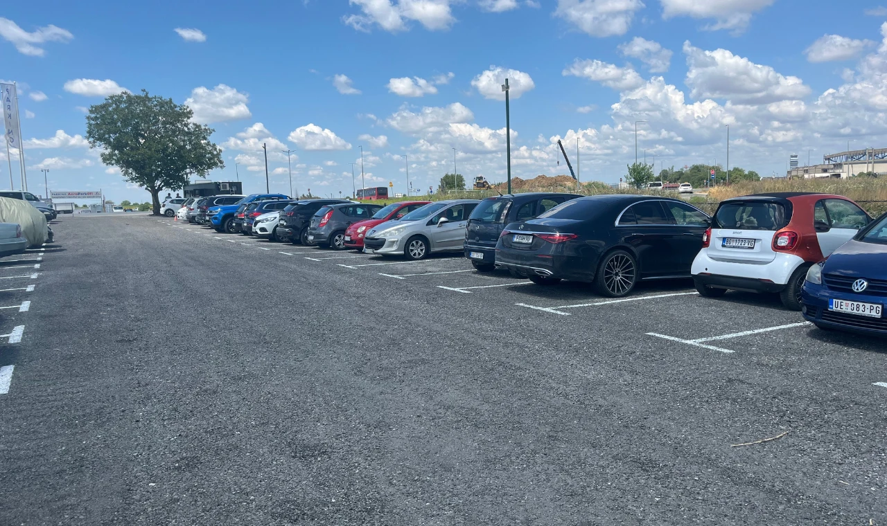 Ograđen parking plac AS Park 011 kod aerodroma Nikola Tesla sa parkiranim vozilima